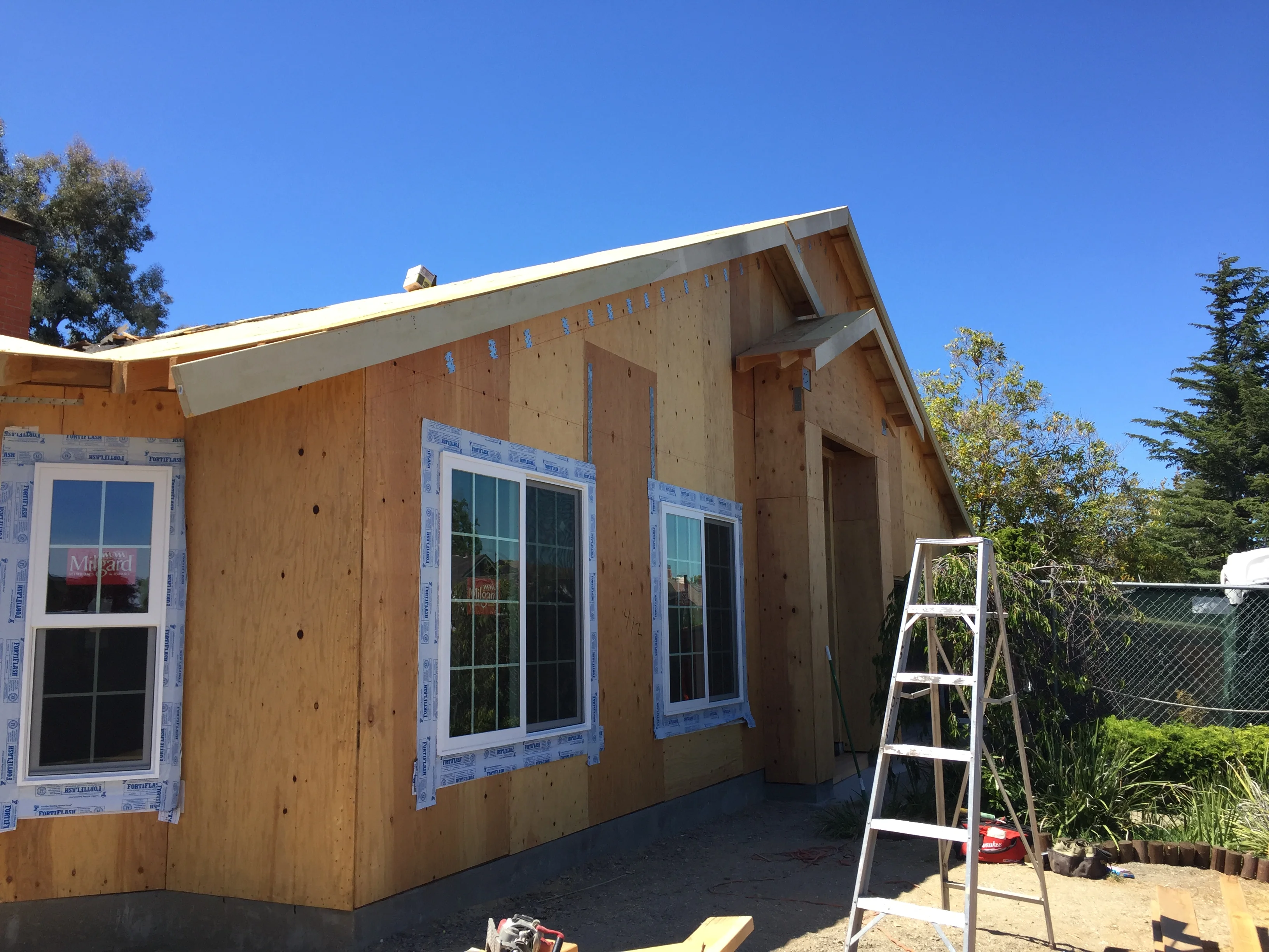 ADU framing with plywood sheathing, house wrap, and installed windows under construction