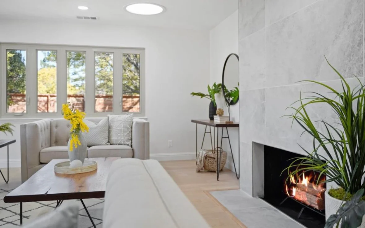 Modern living room with white shiplap walls, wood flooring, fireplace, and recessed lighting