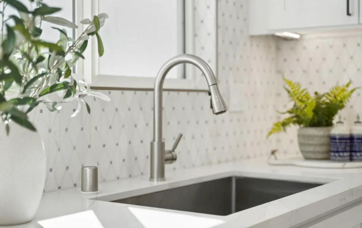 Stainless steel undermount sink with brushed nickel pull-down faucet and white quartz countertop