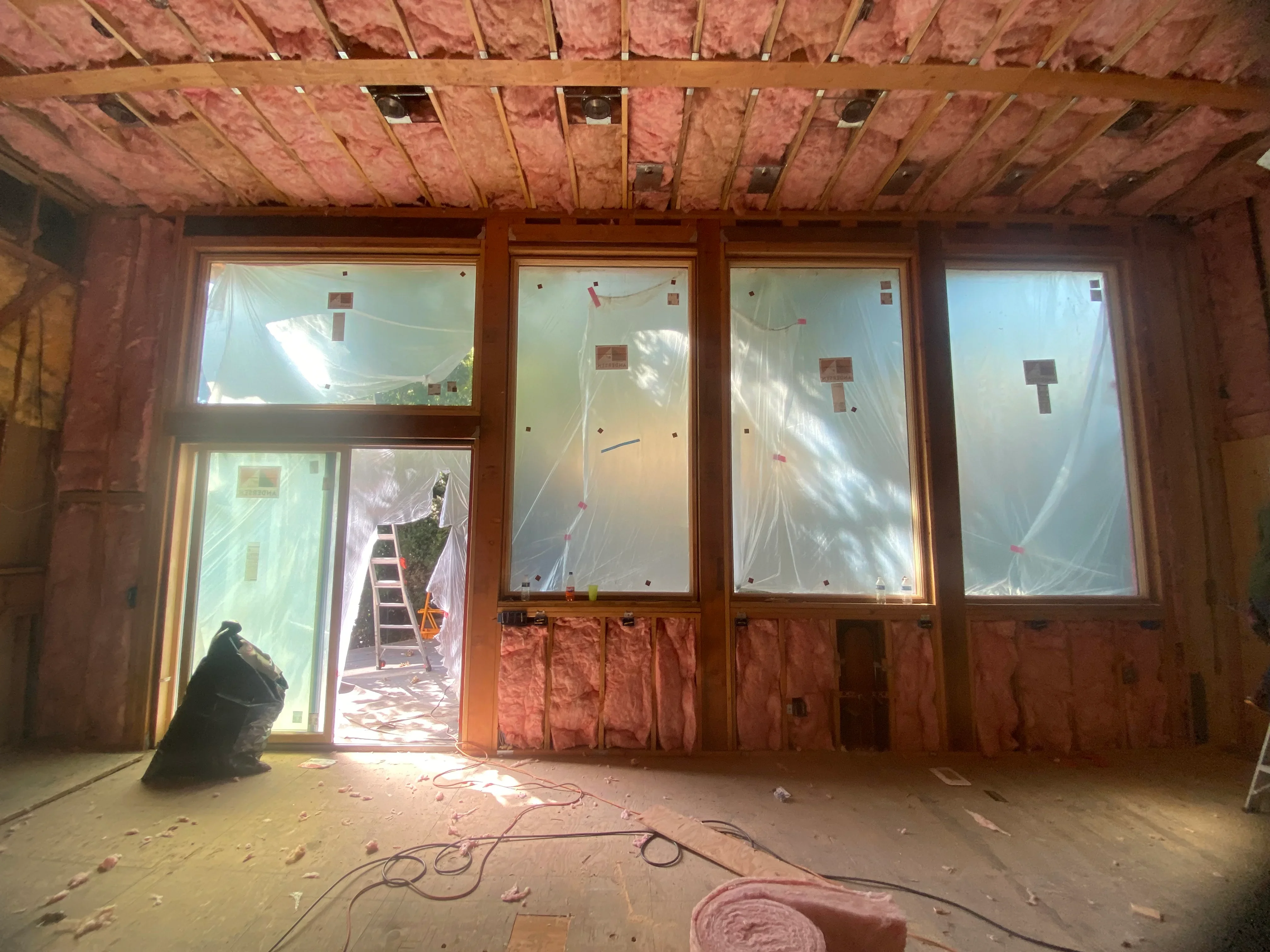 Commercial interior with framed windows, pink insulation, and electrical rough-in during construction