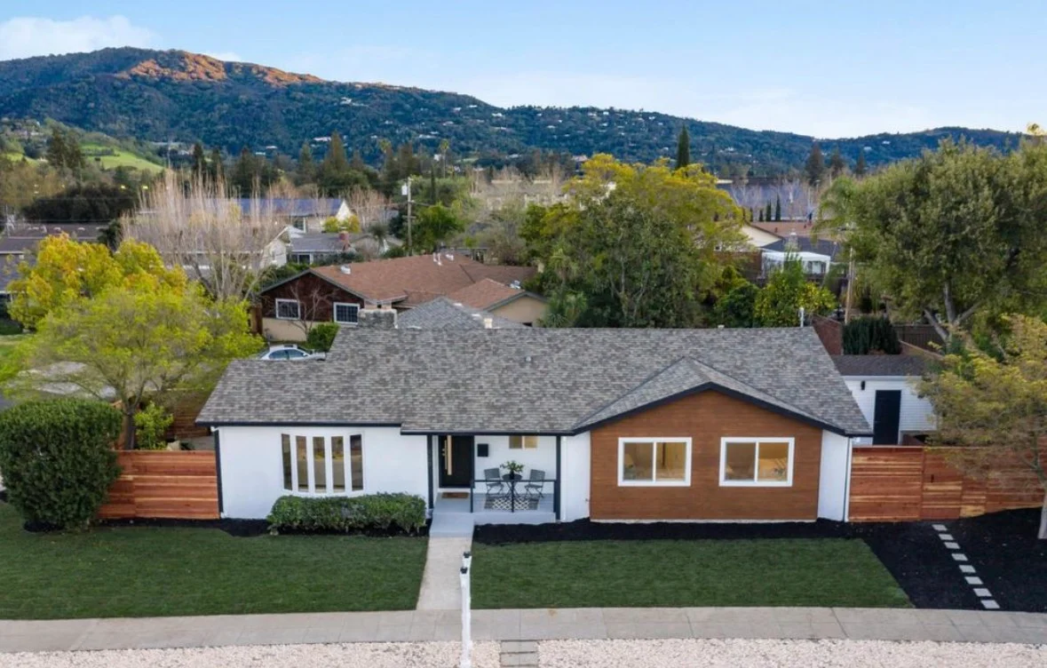 Modern home with wood and white composite cladding, new roof, updated windows, and horizontal wood fencing