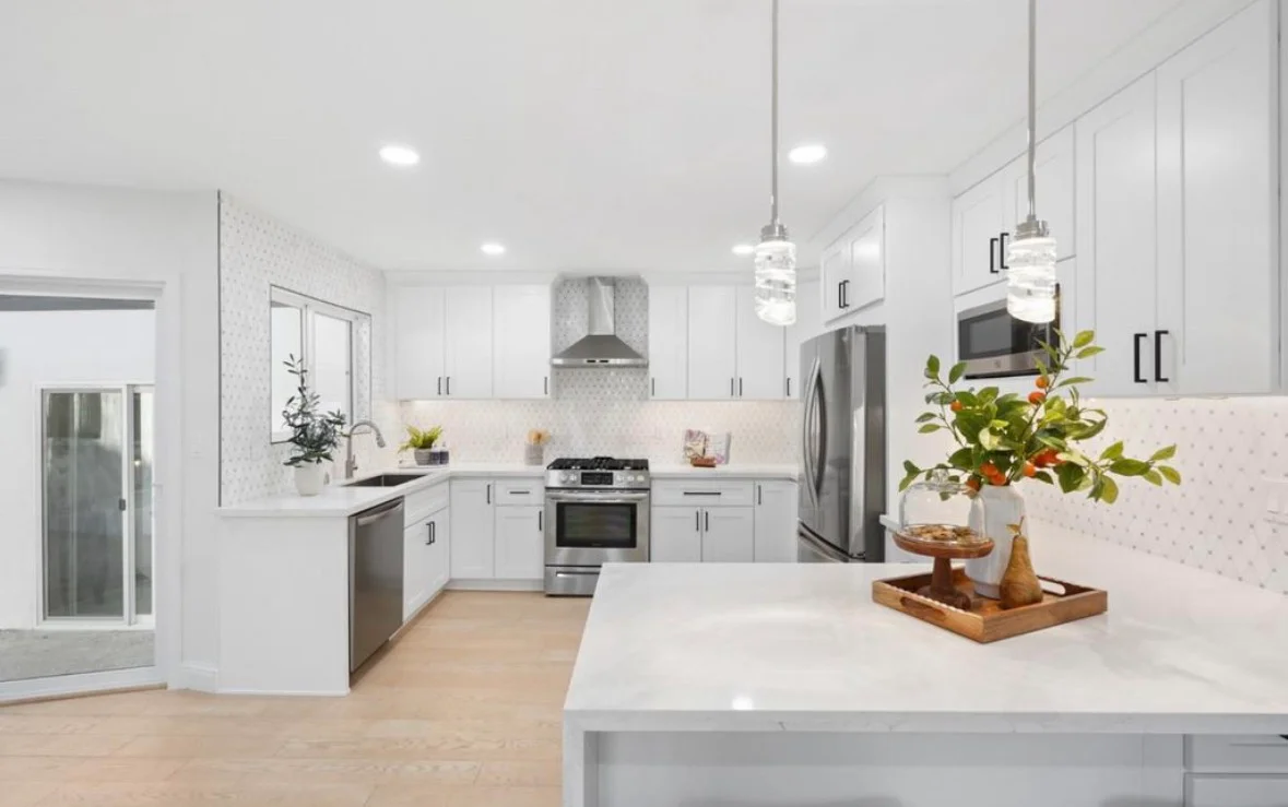 White kitchen with shaker cabinets, quartz counters, subway tile backsplash, and stainless steel appliances