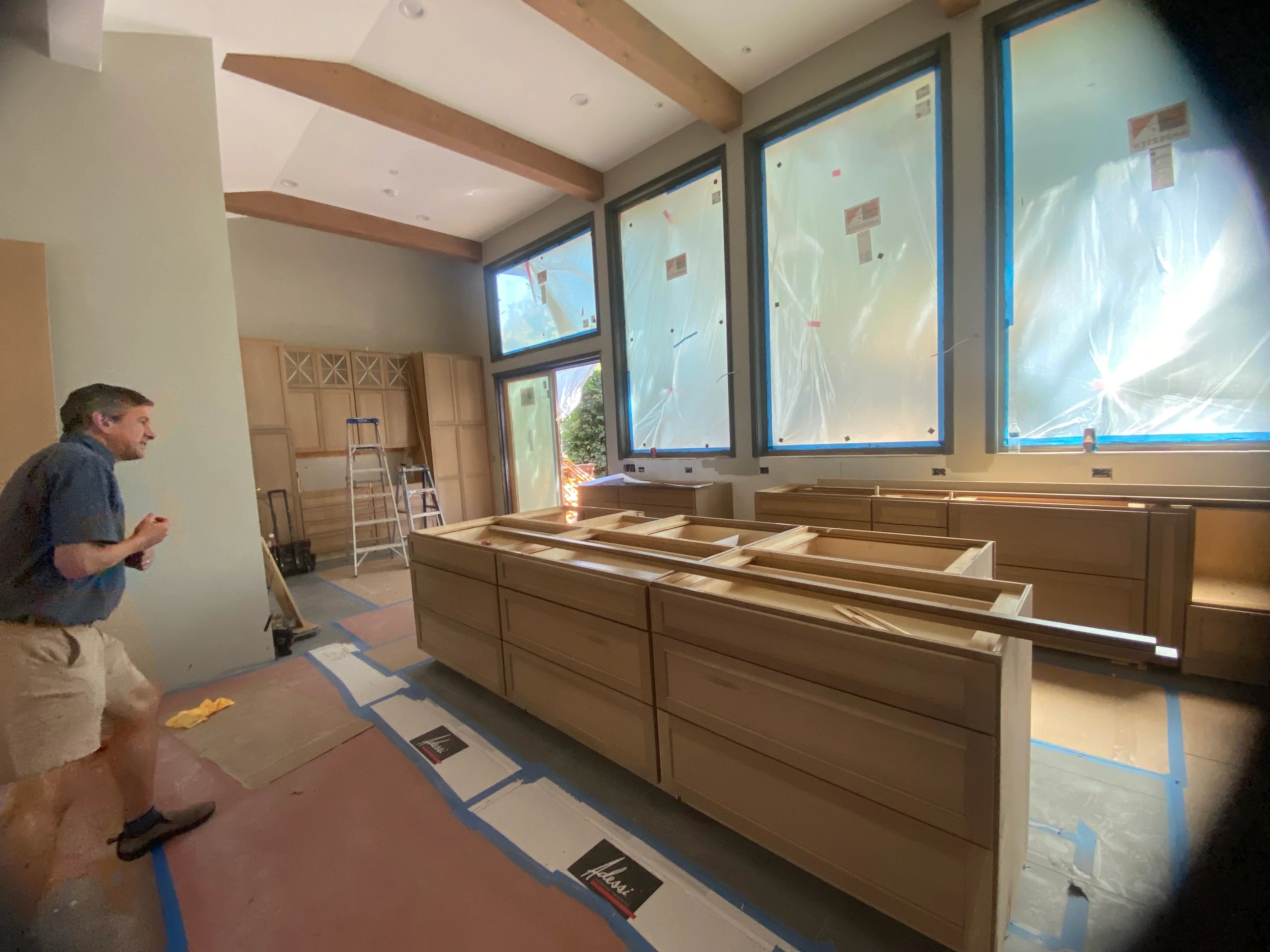 Kitchen remodeling with wood cabinetry installation and protective window coverings