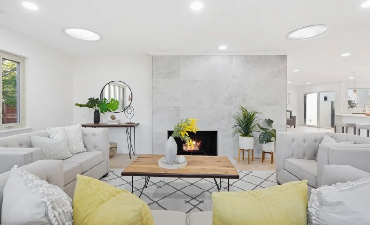 Modern living room with marble accent wall, fireplace, recessed lighting, and gray upholstered furniture