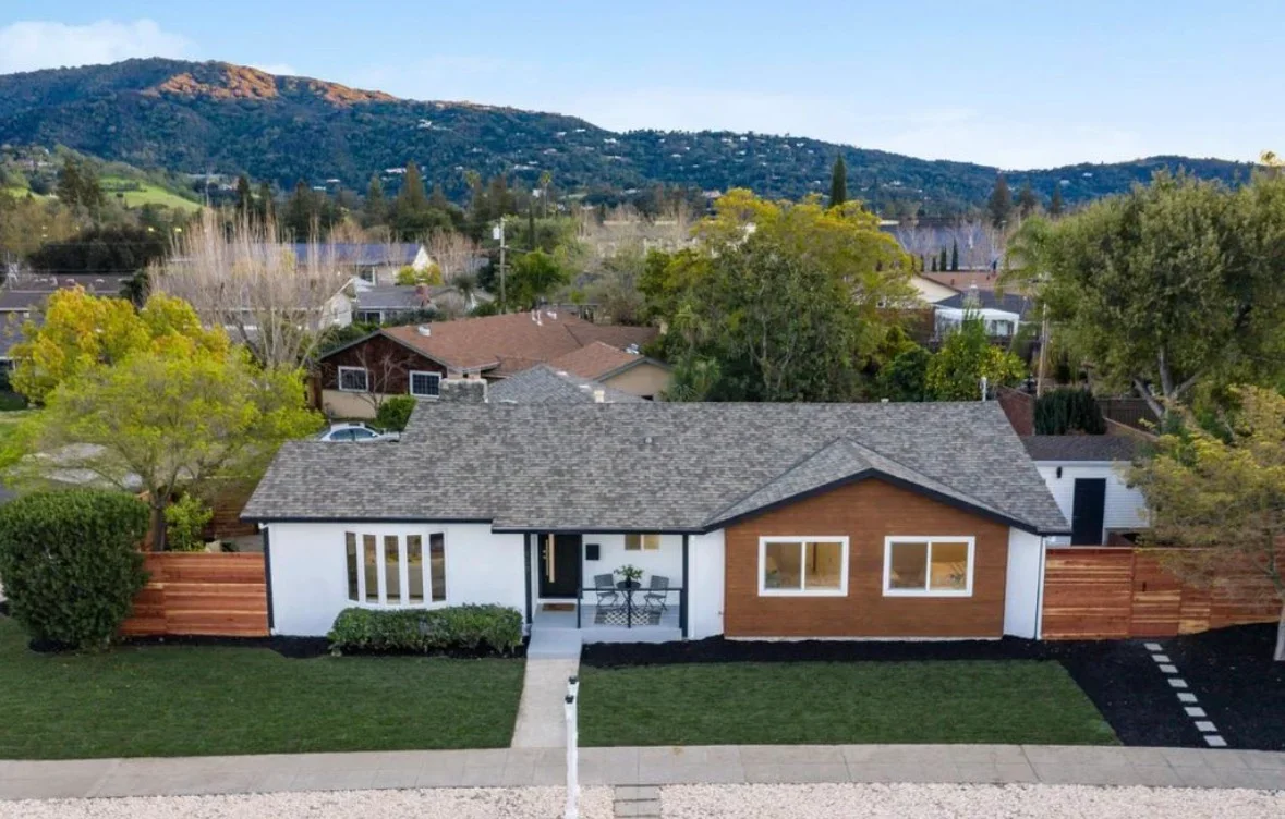 Modern renovated mid-century home with wood and white siding, new roof, and updated fencing